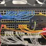 Network switch with colorful patch cables connected, illustrating IT infrastructure and services provided by Clear Sailing IT Services.